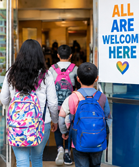 Students with backpacks entering a welcoming school